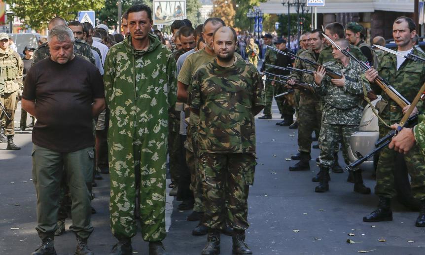 Armed pro-Russian separatists (R) escort a column of Ukrainian prisoners of war as they walk across central Donetsk